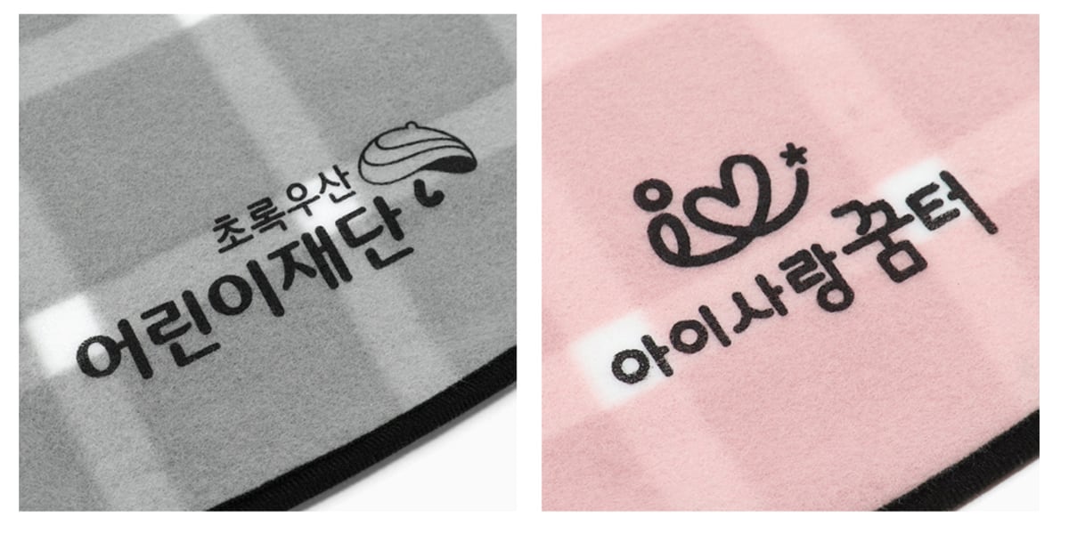 회색 체크 담요에 「초록우산 어린이재단」, 분홍 체크 담요에 「아이사랑꿈터」 로고를 검정 실크인쇄로 찍은 확대 모습